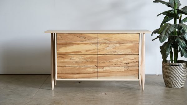 Maple dresser with eight drawers. Legs are artfully shaped and exposed on the outside of the case of drawers.