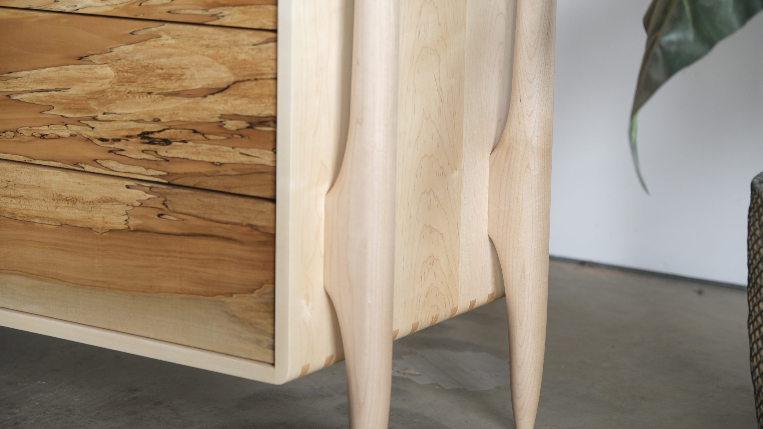 Close-up of the hand turned exposed dresser legs in maple