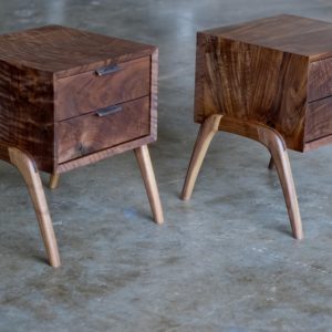 A set of walnut nightstands, each with two drawers and leather pulls.