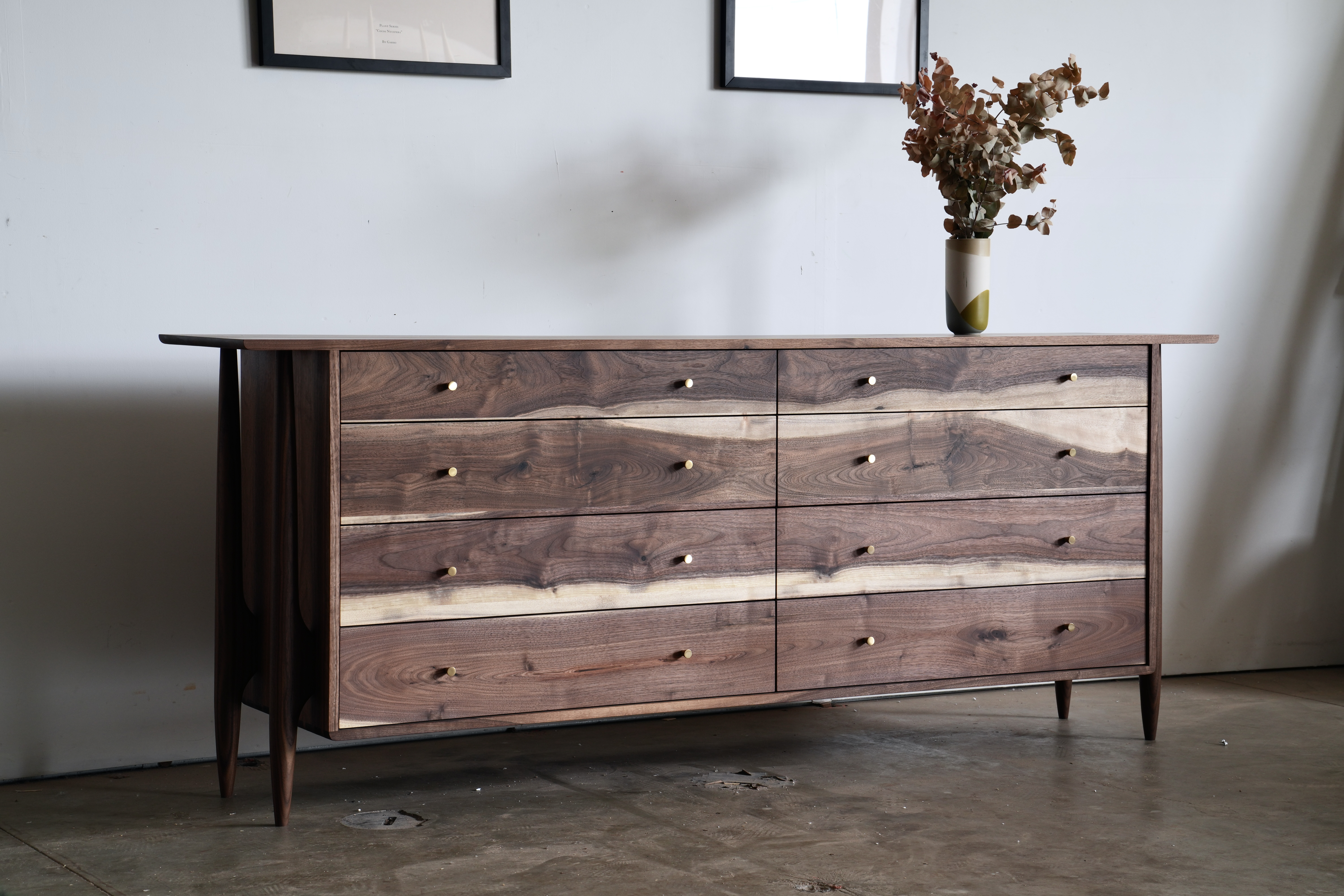 A midcentury modern dresser with 6 drawers made of walnut with sapwood.