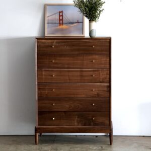 A tall solid walnut dresser with 6 drawers and brass knobs