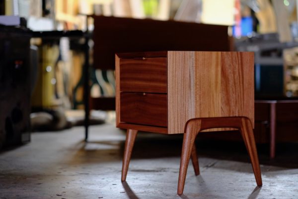 A two-drawer mahogany nightstand with rounded legs