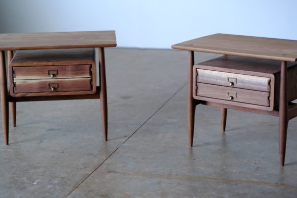 Two handmade side tables that are Scandinavian style, with the drawers appearing to float under the table top and made of solid walnut.
