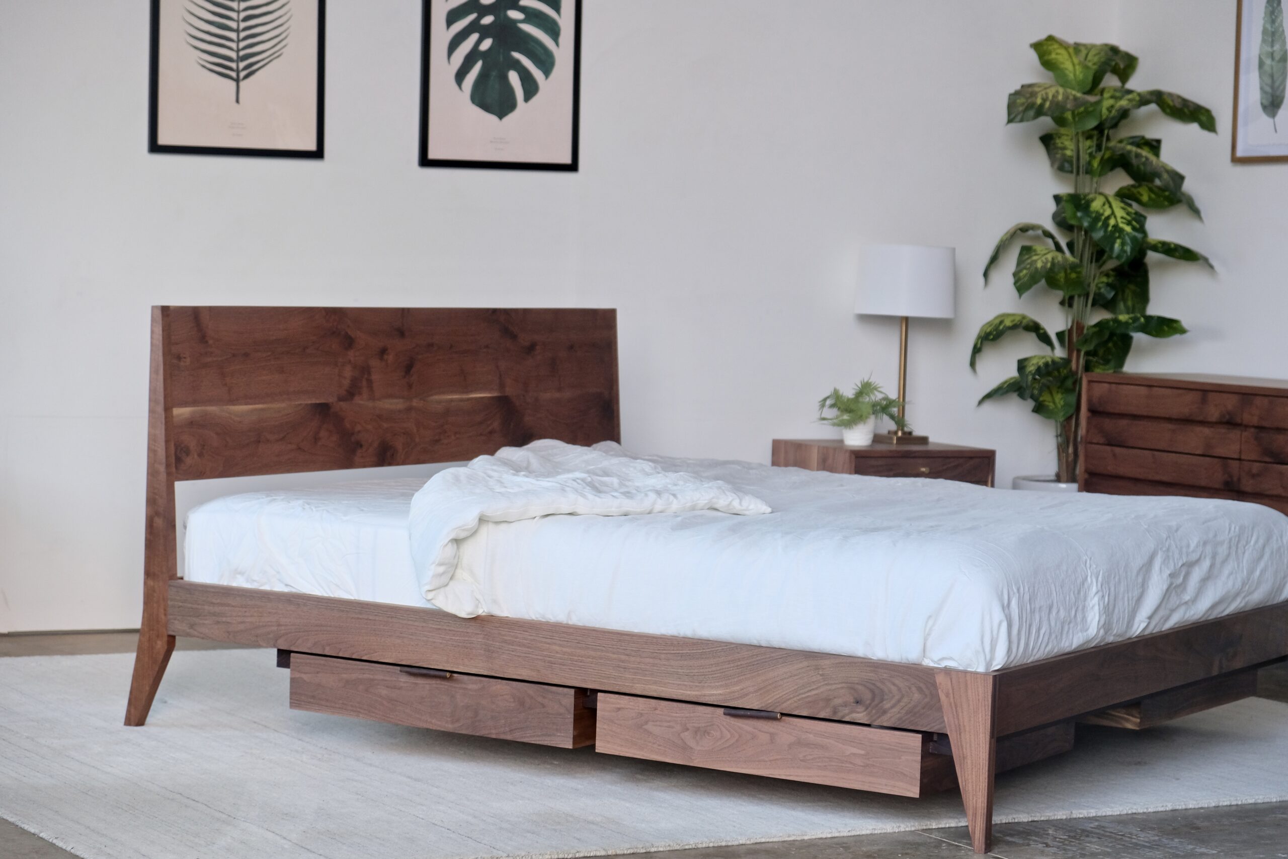 A walnut bed with drawers suspended underneath.