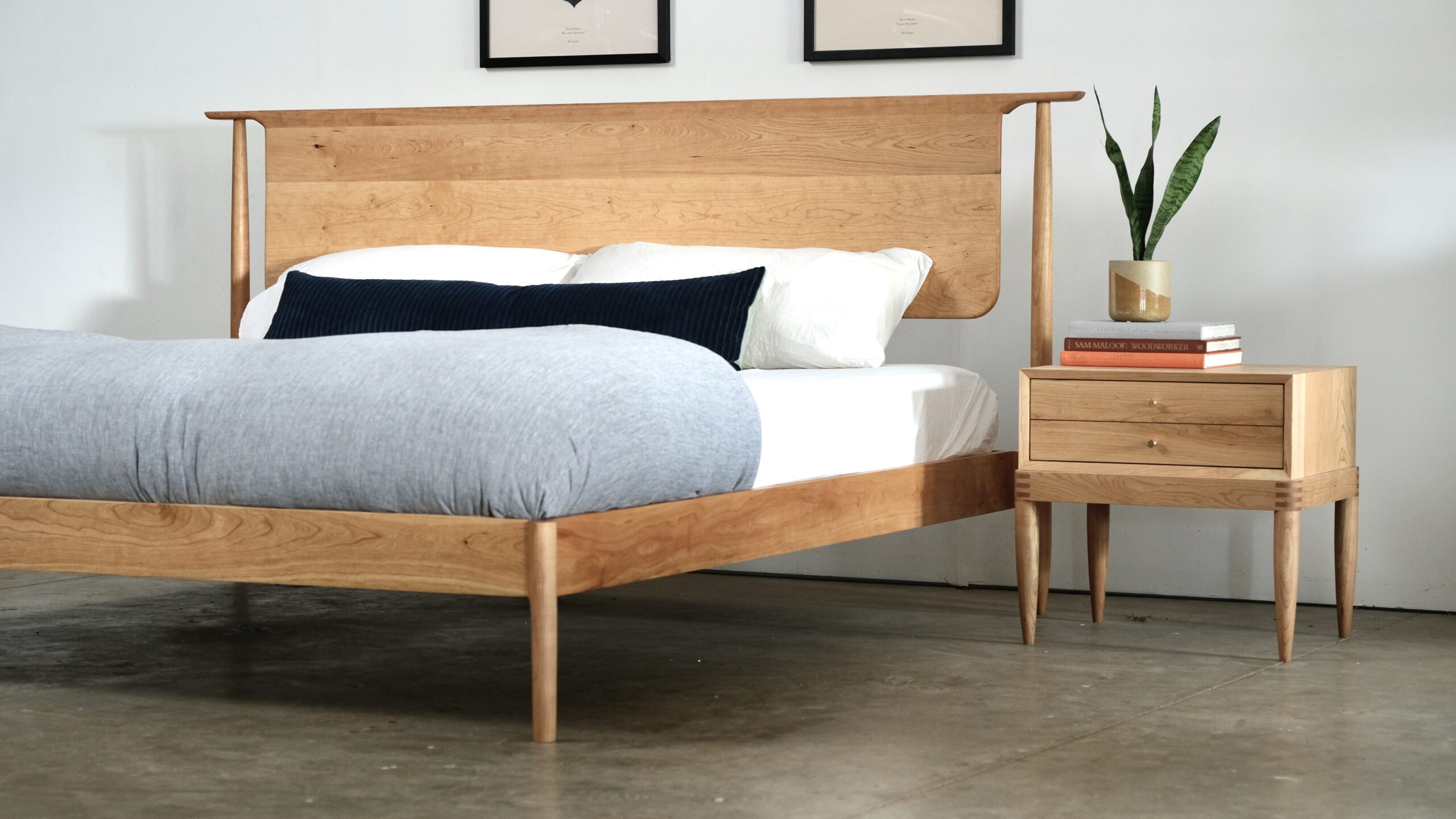 A mid century modern bed and nightstand made from solid cherry.