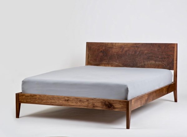 A solid walnut bed using mortise and tenon joinery at the footboard.